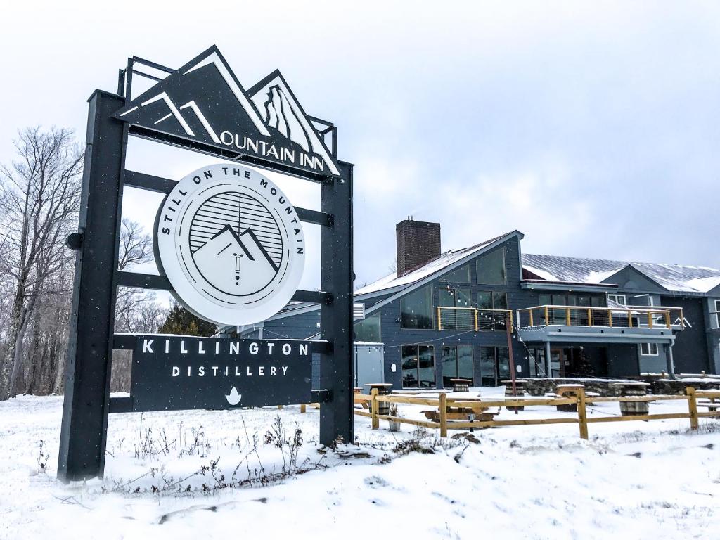 un cartel en la nieve frente a un edificio en Mountain Inn at Killington, en Killington