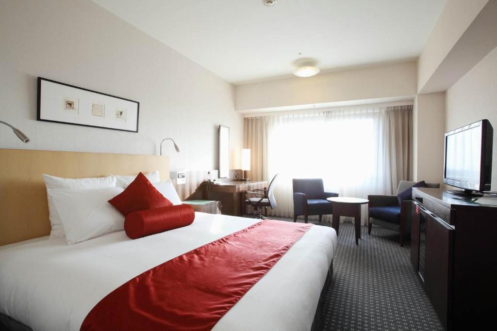 ein Hotelzimmer mit einem Bett und einem TV in der Unterkunft ANA Crowne Plaza Narita, an IHG Hotel in Narita