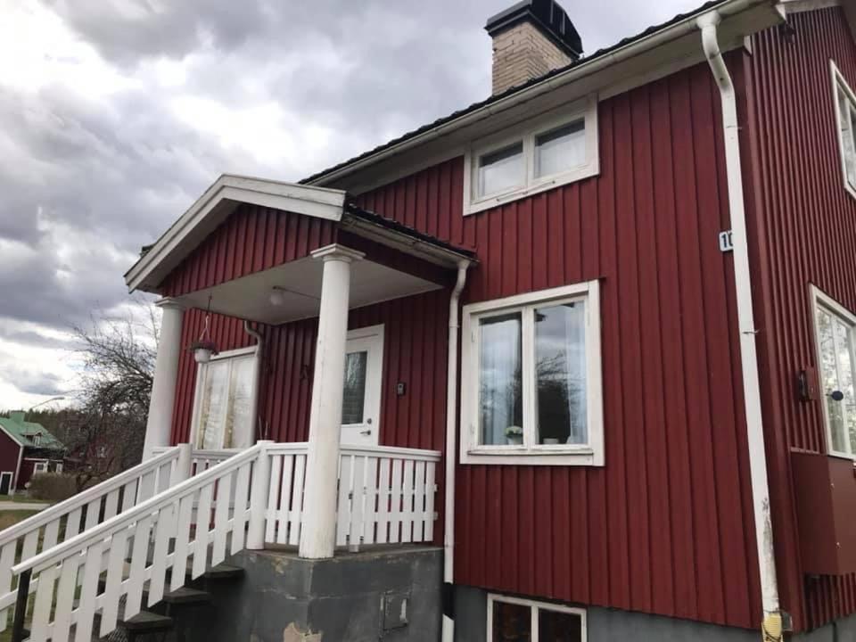 a red house with a white railing at Säfsen in Fredriksberg