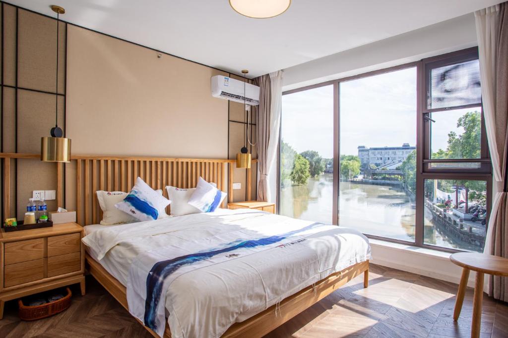蘇州的住宿－同里泊·晓烟河景民宿，一间卧室设有一张大床和一个大窗户