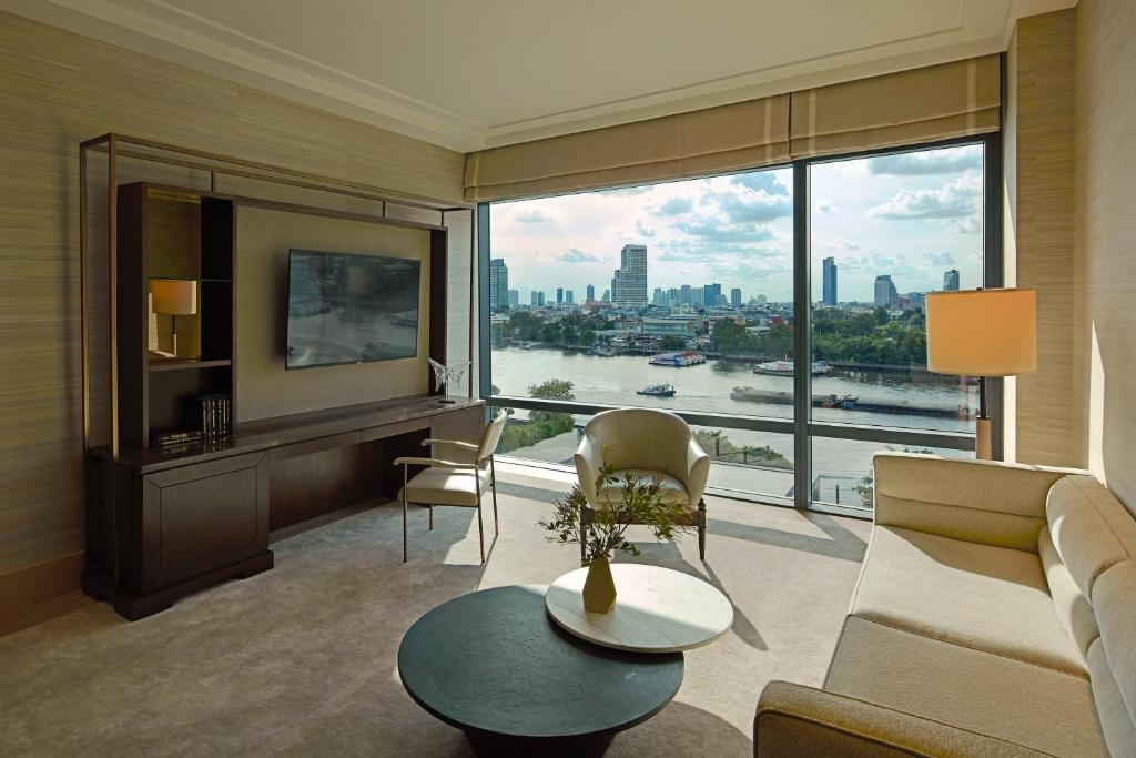 A river-facing lounge with generous glazing and a separate desk chair.