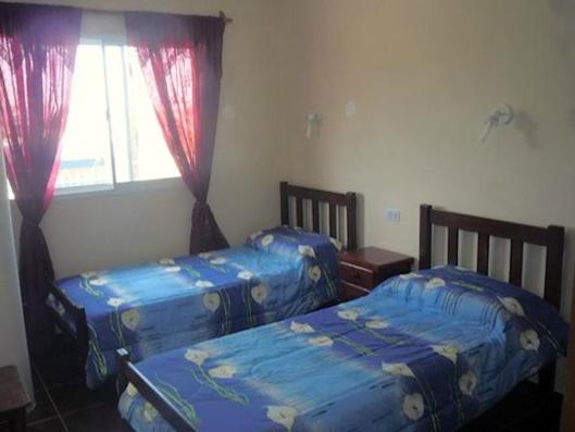 a bedroom with two beds and a window at Hotel Ruma in Salta