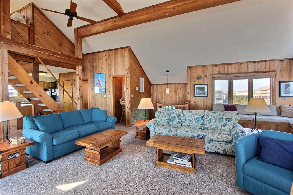 a living room with blue furniture and wooden walls at Three Sheets to the Wind #70-1 in Avon