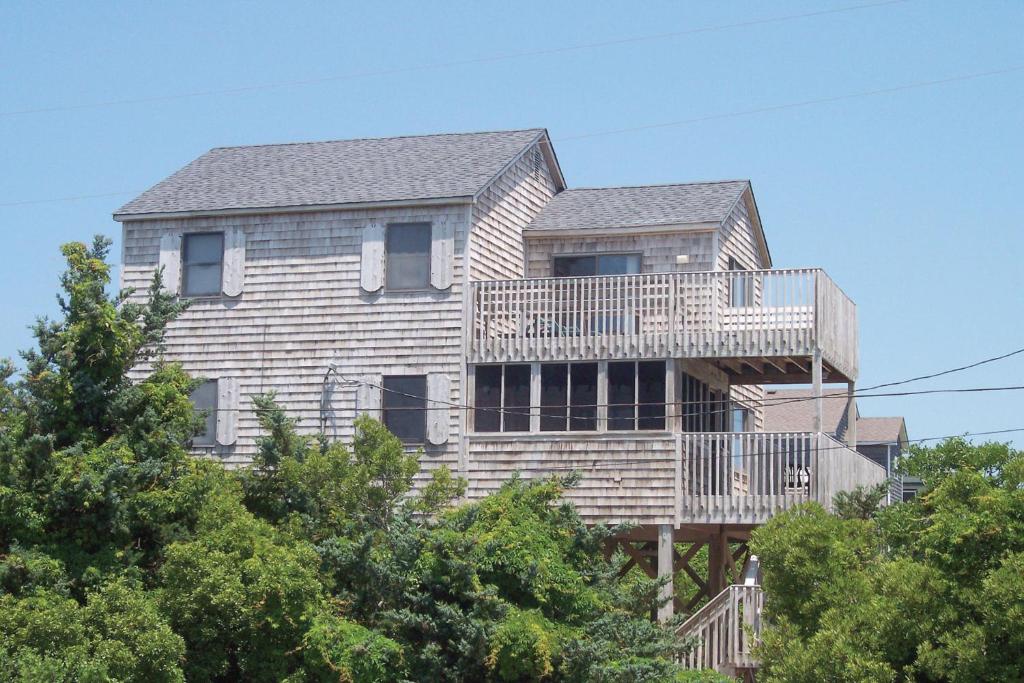 une grande maison avec une terrasse au sommet des arbres dans l'établissement Offshore #50-1, à Avon
