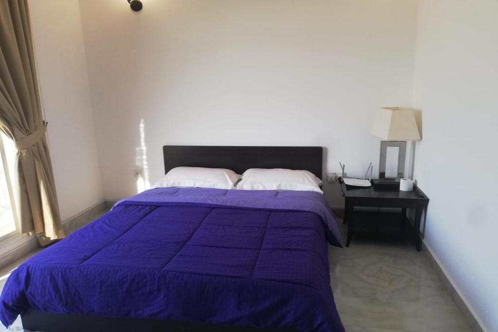 a bedroom with a purple bed with a nightstand and a window at OYO 621 Home Habtoor studio's in Dubai