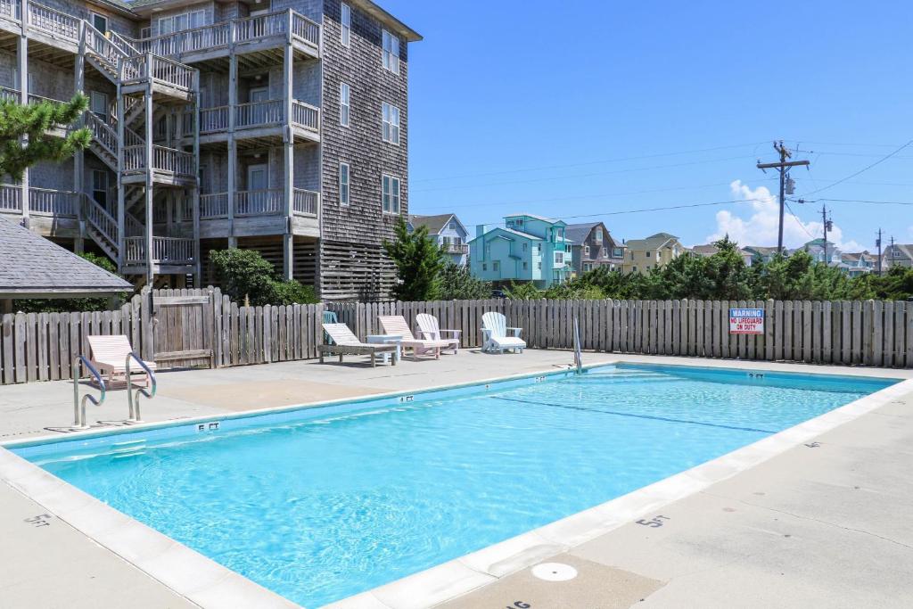 a swimming pool with chairs and a fence at 41057-2 Hwy 12 Islander Condo in Avon