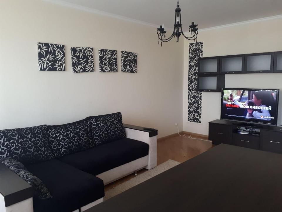 Апартаменти на Чорновола, Порт-сіті في لوتسك: غرفة معيشة مع أريكة وتلفزيون