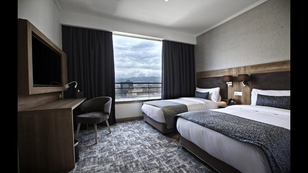 貝魯特的住宿－Hotel De Ville，酒店客房设有两张床和窗户。