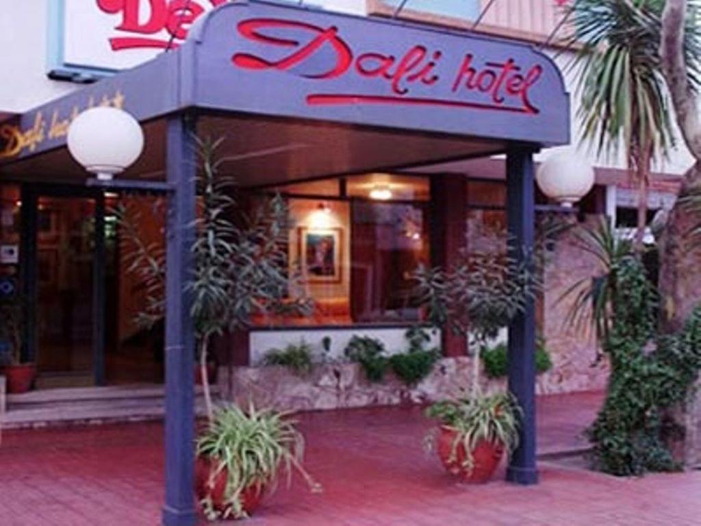 a restaurant with potted plants in front of a building at Hotel Dali in San Rafael