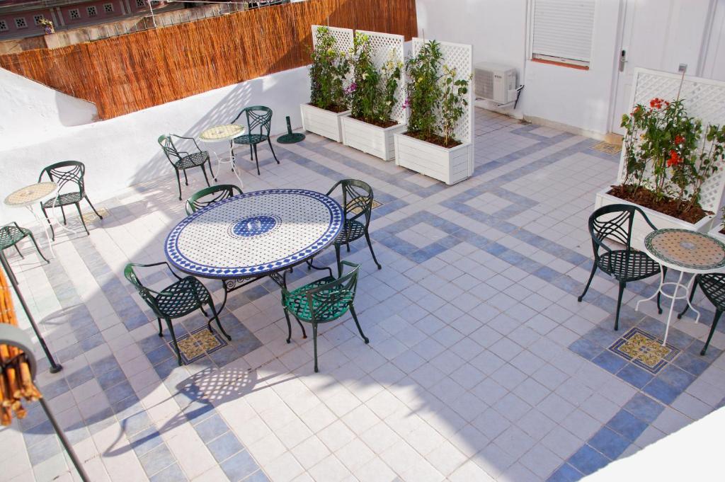 un patio al aire libre con mesas, sillas y plantas en Hostal Colkida, en Barcelona