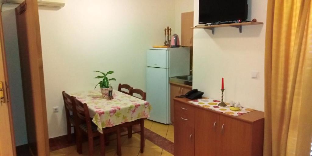 eine kleine Küche mit einem Tisch und einem Kühlschrank in der Unterkunft Casa Del Sol Bed&Breakfast in Sukošan