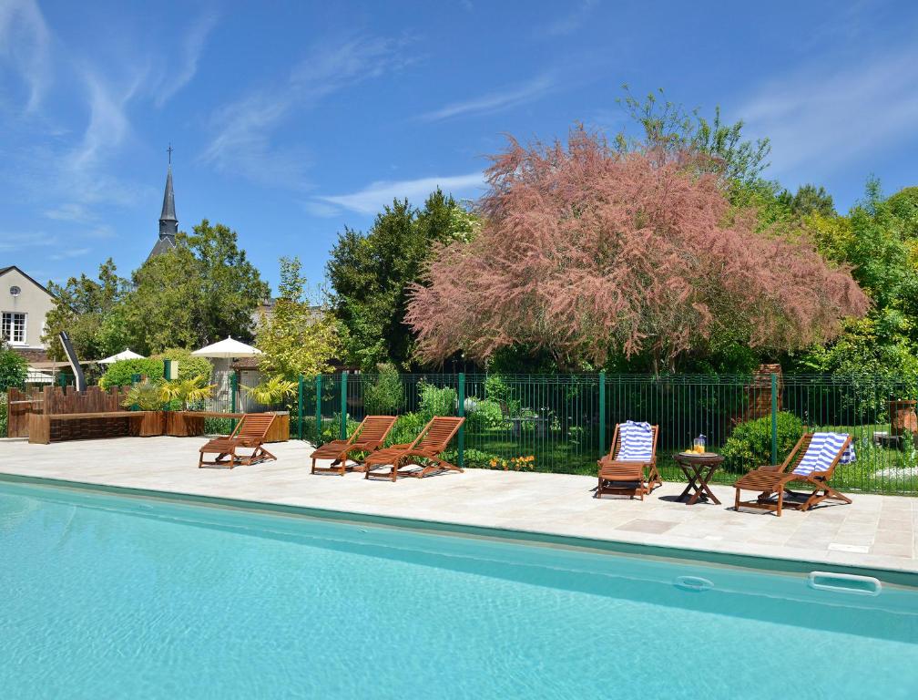 - un groupe de chaises longues et une piscine dans l'établissement Logis Auberge Du Centre, à Chitenay