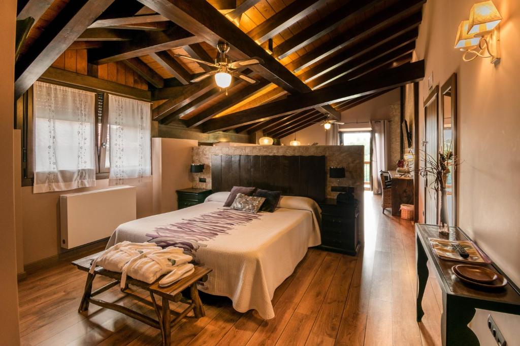 Un dormitorio con una cama grande en una habitación con techos de madera. en Casa Rural Aldekoa, en Ziga