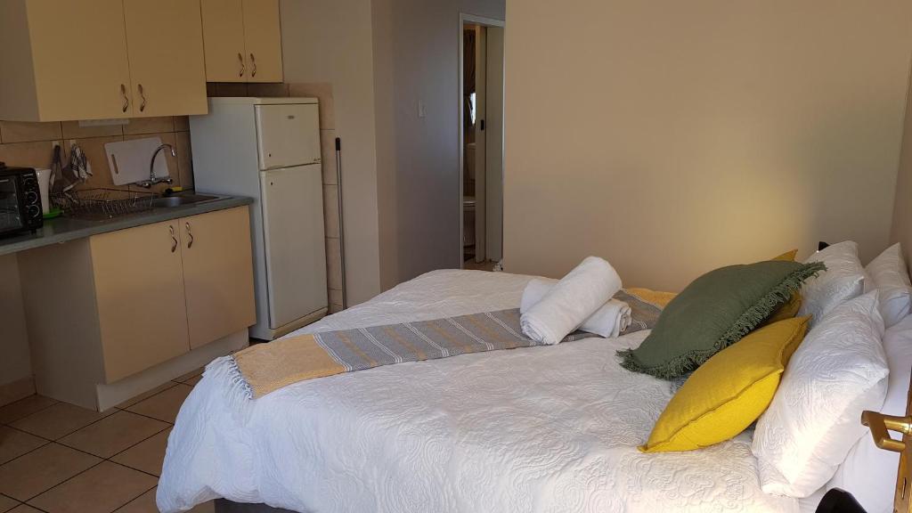 Accommodation@Park1285 في بريتوريا: غرفة نوم بسرير ابيض عليها مخدات