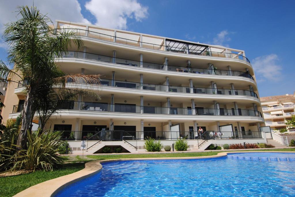 un hôtel avec une piscine en face d'un bâtiment dans l'établissement 196 Terrazas de Las Marinas - Deniasol, à Dénia