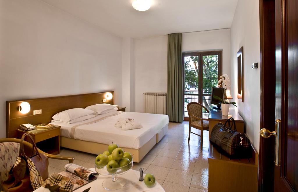 SegniにあるAlbergo La Paceのベッドとテーブルが備わるホテルルームです。