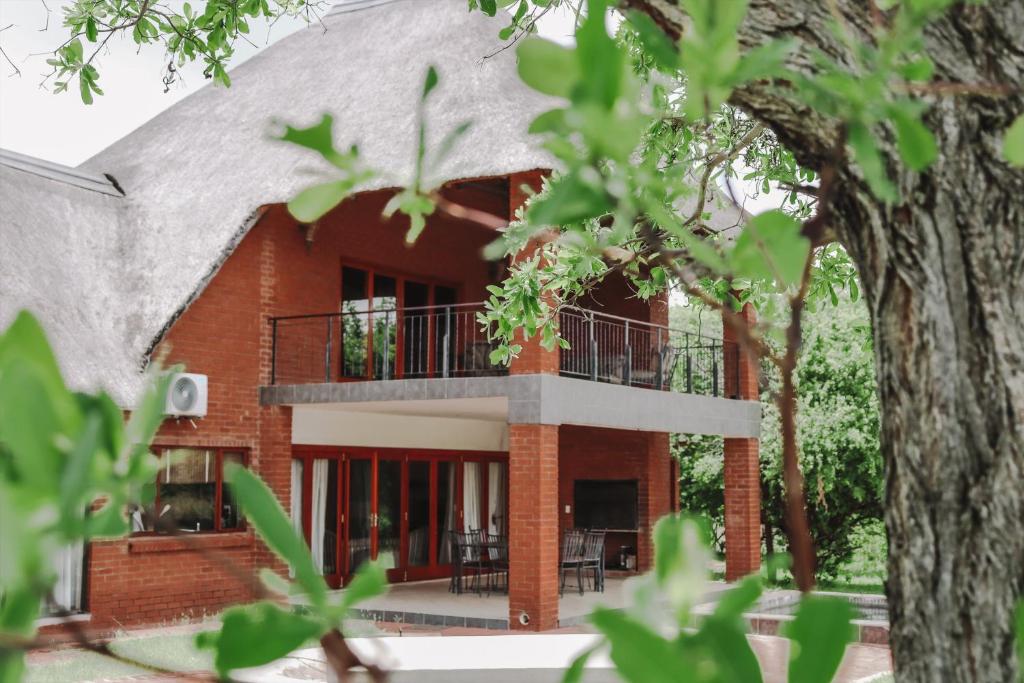 a red brick house with a thatched roof at 119 Zebula in Mabula