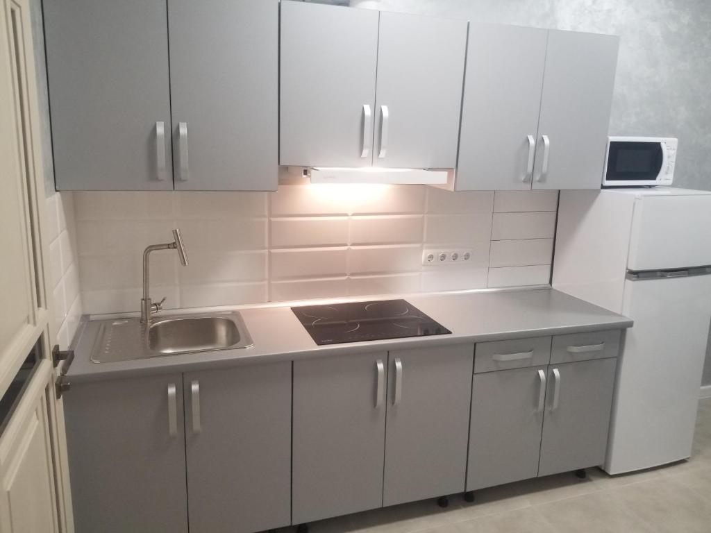 a kitchen with white cabinets and a sink at Апартаменти Віланж in Polyana