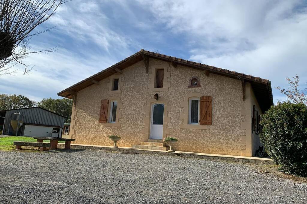 Gîte au coeur de la ferme في Hauriet: بيت حجري صغير أمامه جلسة