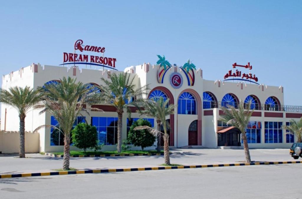 a building with palm trees in front of it at Ramee Dream Resort in Seeb