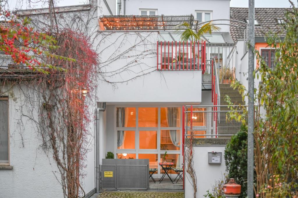 マルクドルフにあるCity Appartementのオレンジ色のドアとバルコニーのある白い家