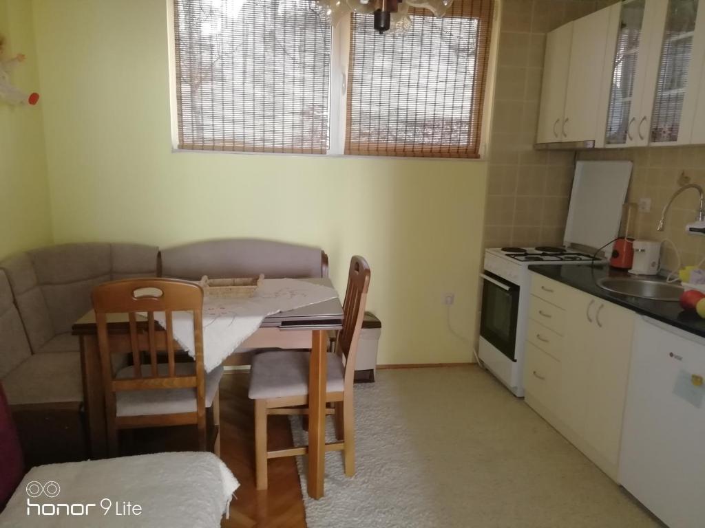 małą kuchnię ze stołem i krzesłami. w obiekcie Apartman Monika Zlatar Nova Varos w mieście Nova Varoš
