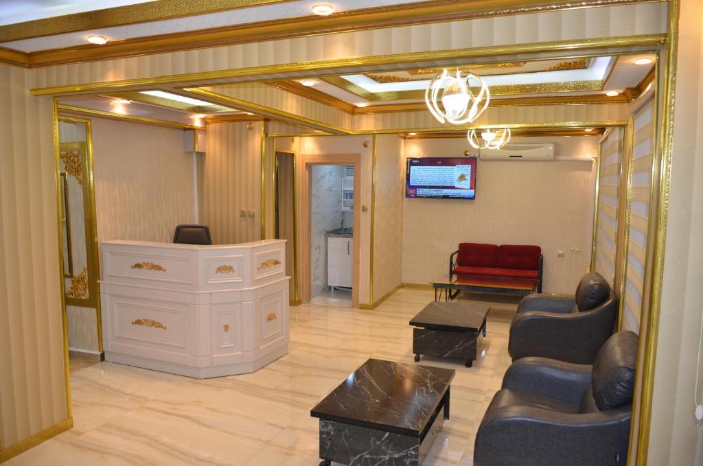 a living room with a tv and a couch and chairs at TABRİZ HOTEL in Istanbul