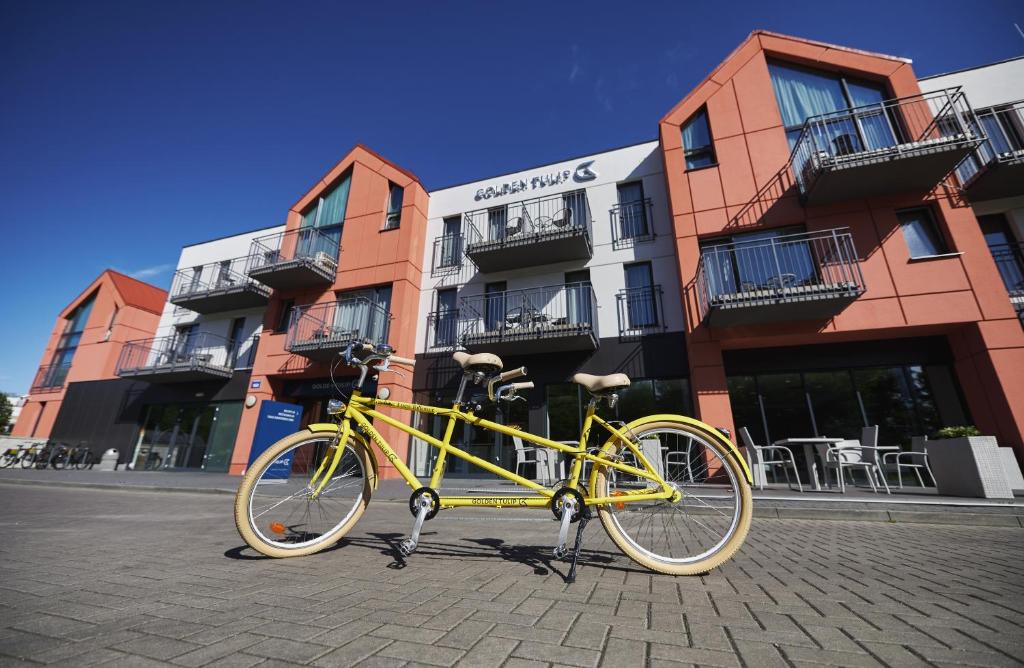 a bicycle parked in front of a brick building at Golden Tulip Gdańsk Residence in Gdańsk