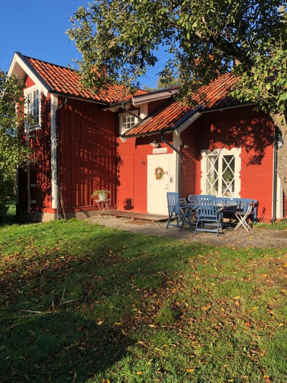 a red house with a table and chairs in front of it at Notholmen, Tyresö in Tyresö