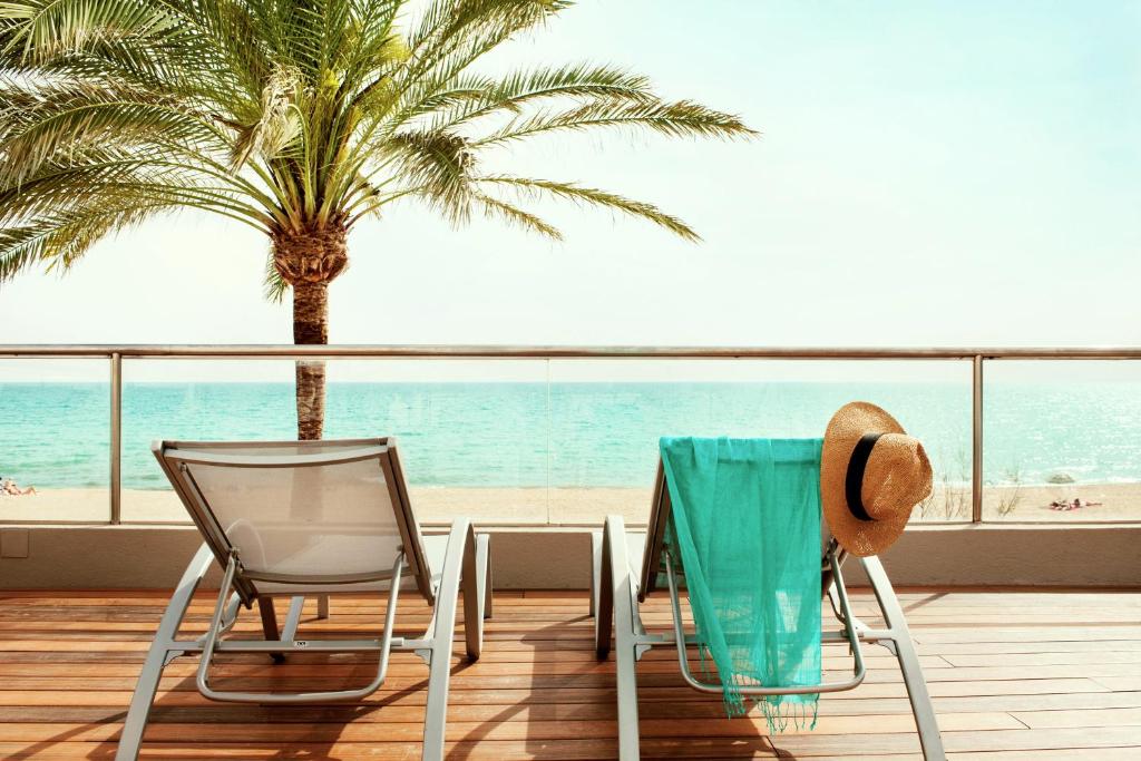 - Balcón con mesa y sillas y vistas a la playa en PALMA BEACH HOTEL Adults Only, en Can Pastilla