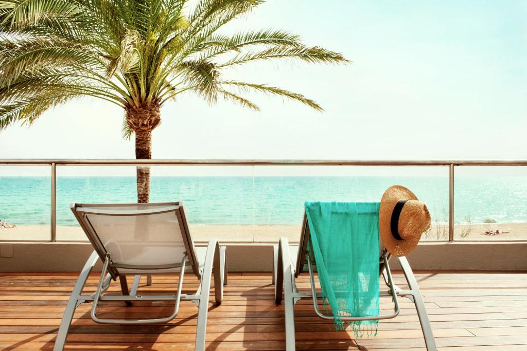 un tavolo e sedie su un balcone con vista sulla spiaggia di PALMA BEACH HOTEL Adults Only a Can Pastilla