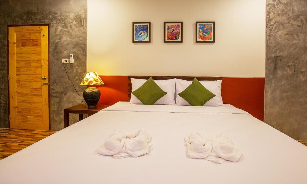 a bedroom with a bed with white towels on it at Phangnga Keeree Resort & Gallery in Phang-nga