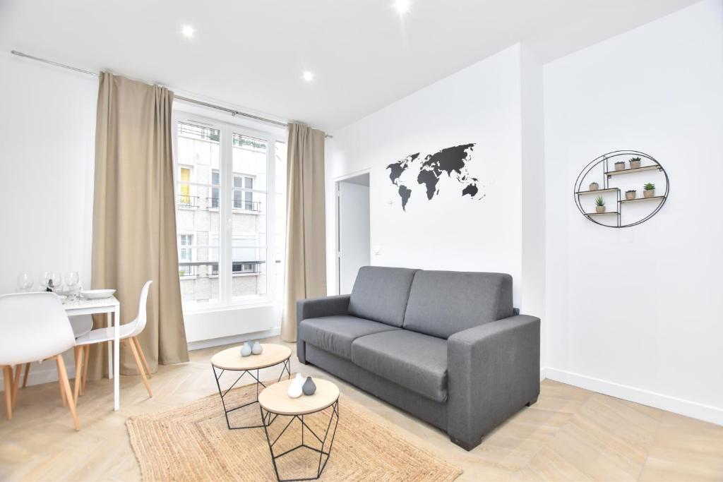 een woonkamer met een bank en een tafel bij Appartement qui touche casiment la Bastille ! in Parijs