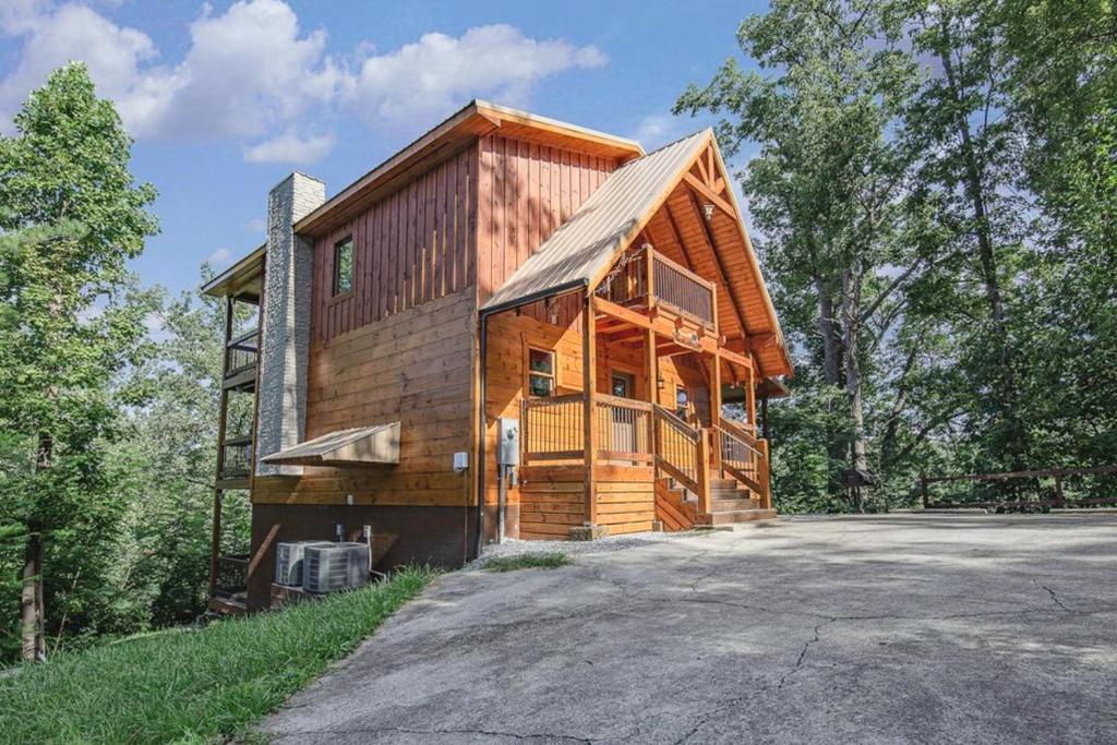 a wooden cabin in the woods with a driveway at Mountainside Escape in Gatlinburg
