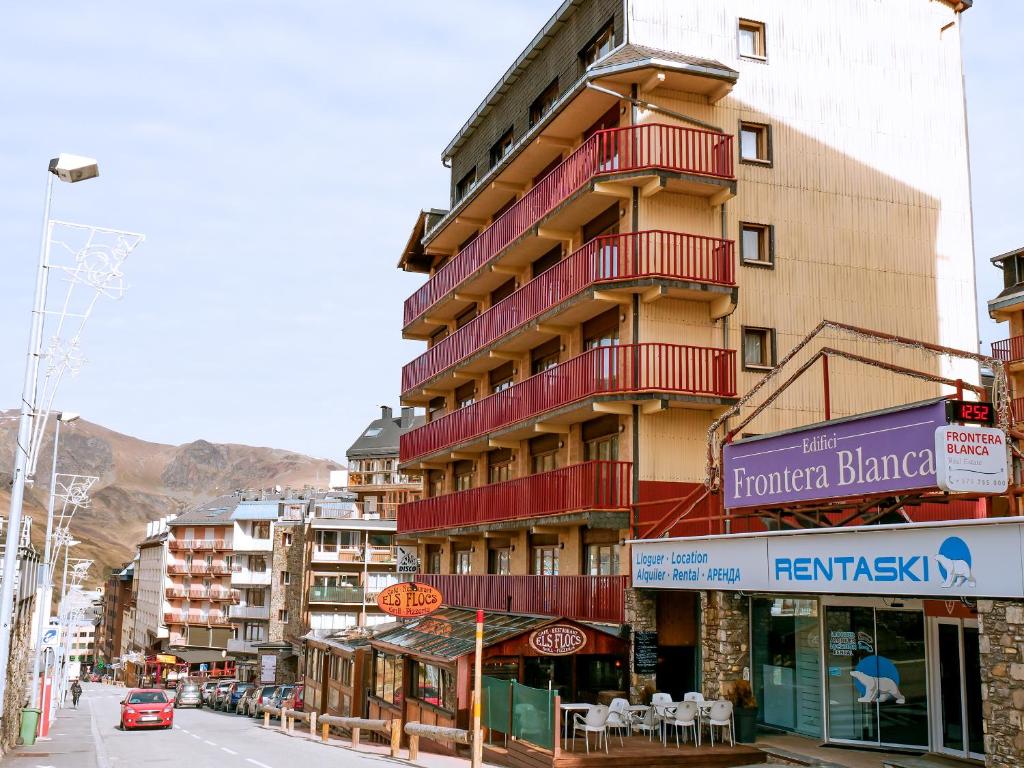 パス・ダ・ラ・カザにあるKione Paradís Blancの市の通りに赤いバルコニー付きの高層ビル