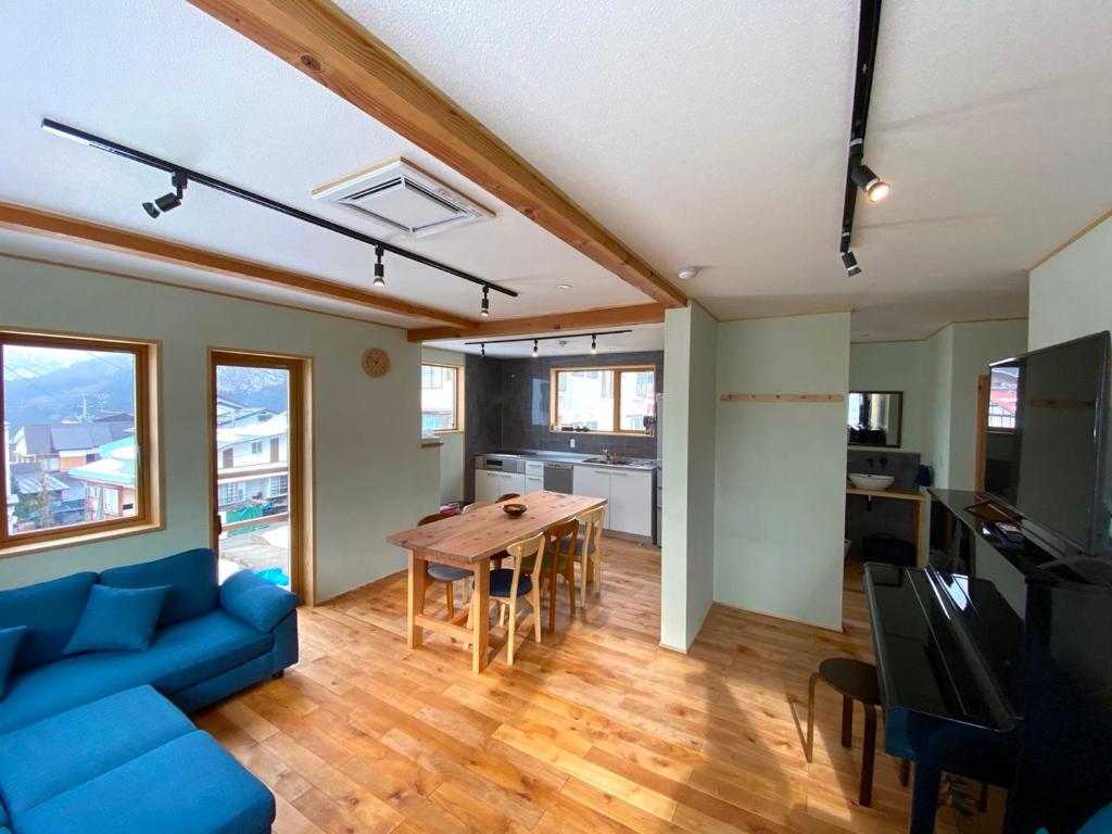 a living room with a blue couch and a table at Montefino - warm wooden chalet in Nozawa Onsen