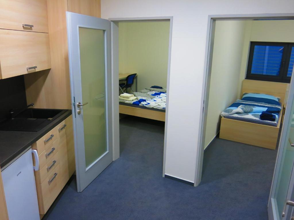 a room with two beds and a door to a kitchen at Elmontex Air in Mošnov