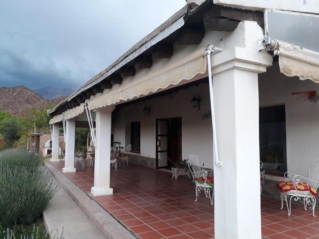 a white house with a patio with tables and chairs at ARK - Una casa con sabor a hogar in Cachí