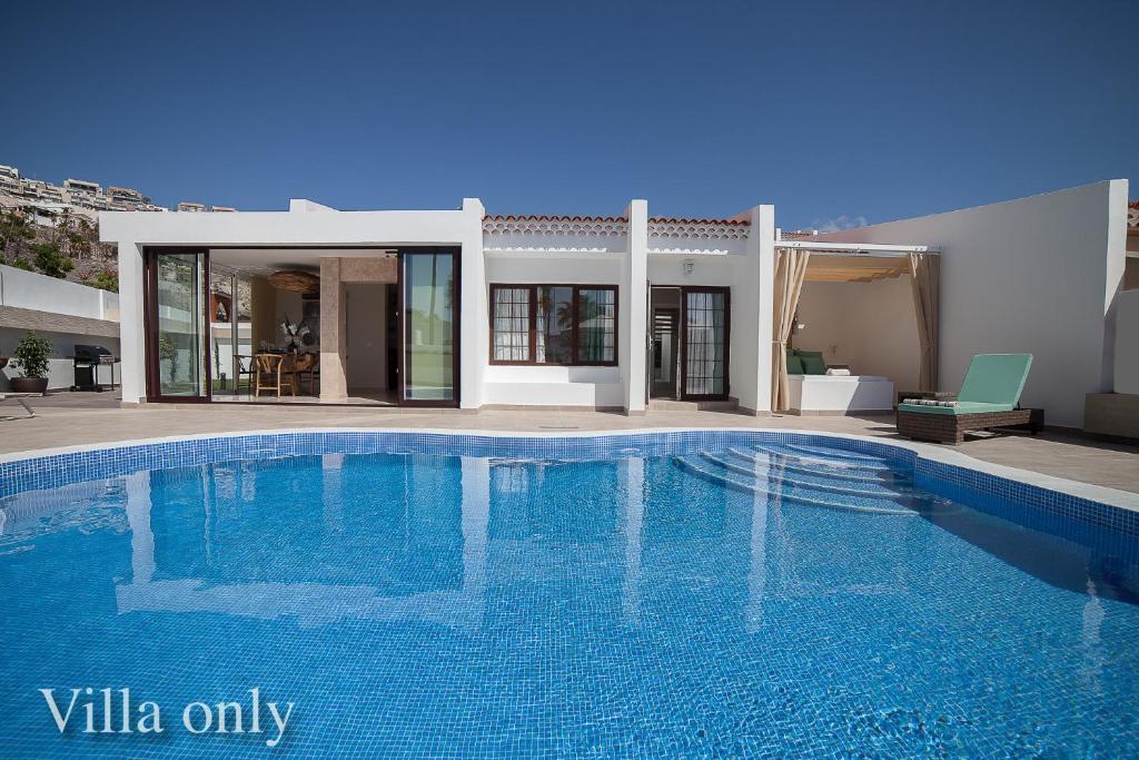 a swimming pool in front of a villa at Haciendas IV in Adeje