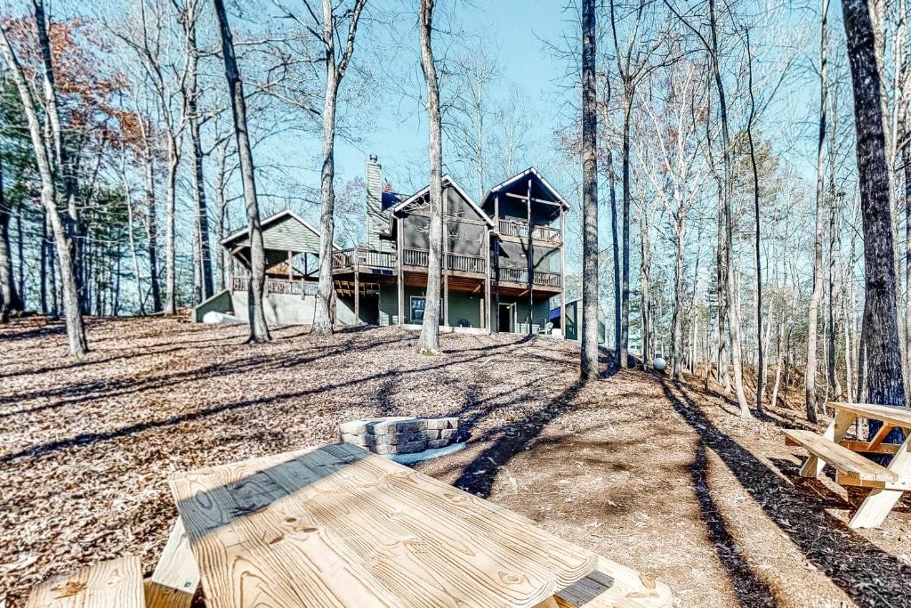 a house in the woods with a picnic table in front at Bearfoot Lodge in Ellijay