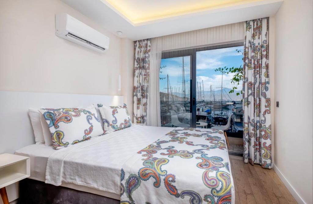 ein Schlafzimmer mit einem Bett und einem großen Fenster in der Unterkunft Ece Marina Suit in Fethiye