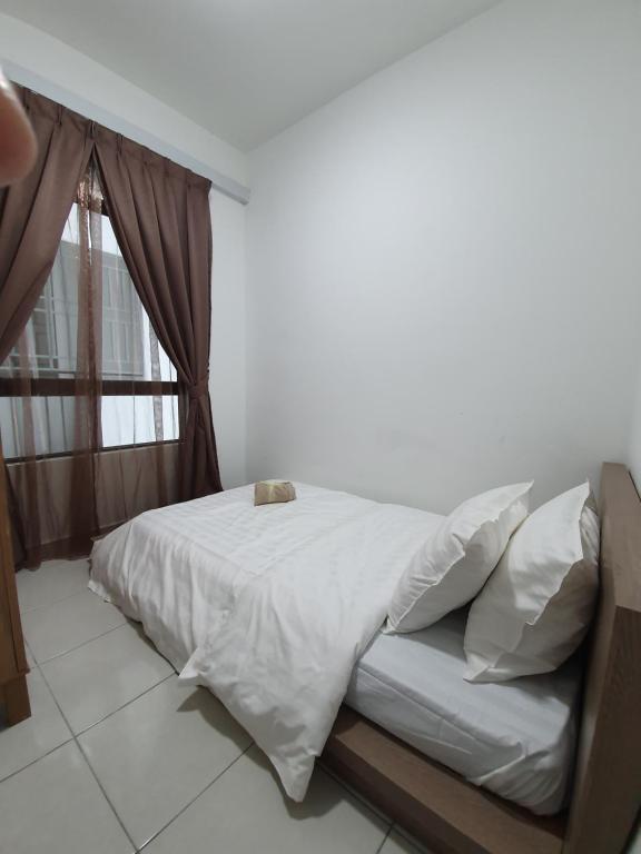 una camera da letto con un letto con lenzuola bianche e una finestra di A29 Benoni Garden Suites a Papar