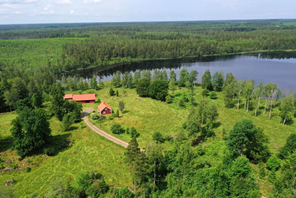een luchtzicht op een boerderij met een rode woning op een heuvel bij een meer bij Holiday home Småland Gäddegölshult in Gäddegölshult