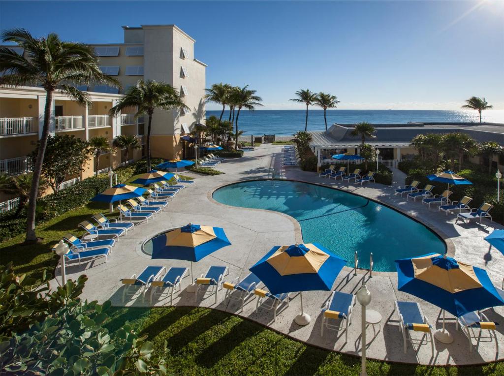una vista aérea de una piscina con sombrillas y el océano en Delray Sands Resort en Boca Raton