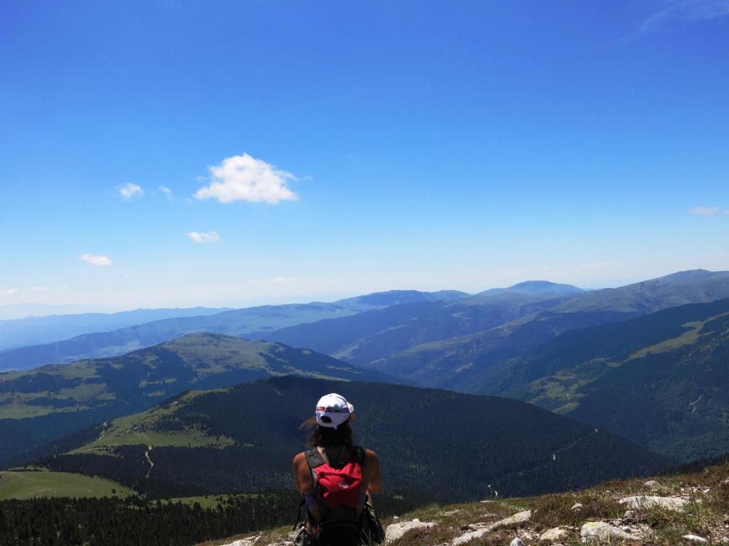 una mujer sentada en la cima de una montaña mirando las montañas en Can Batlló en Molló