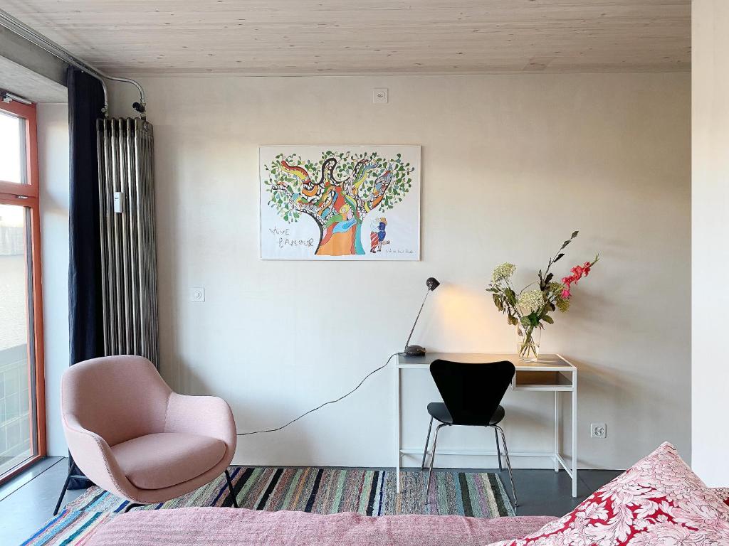 a bedroom with a desk and a chair and a tree at Gästehaus am Lagerplatz in Winterthur