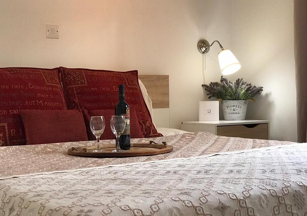 a tray with a bottle of wine and two glasses on a bed at Royal Sunset Studios & Apartments in Limassol