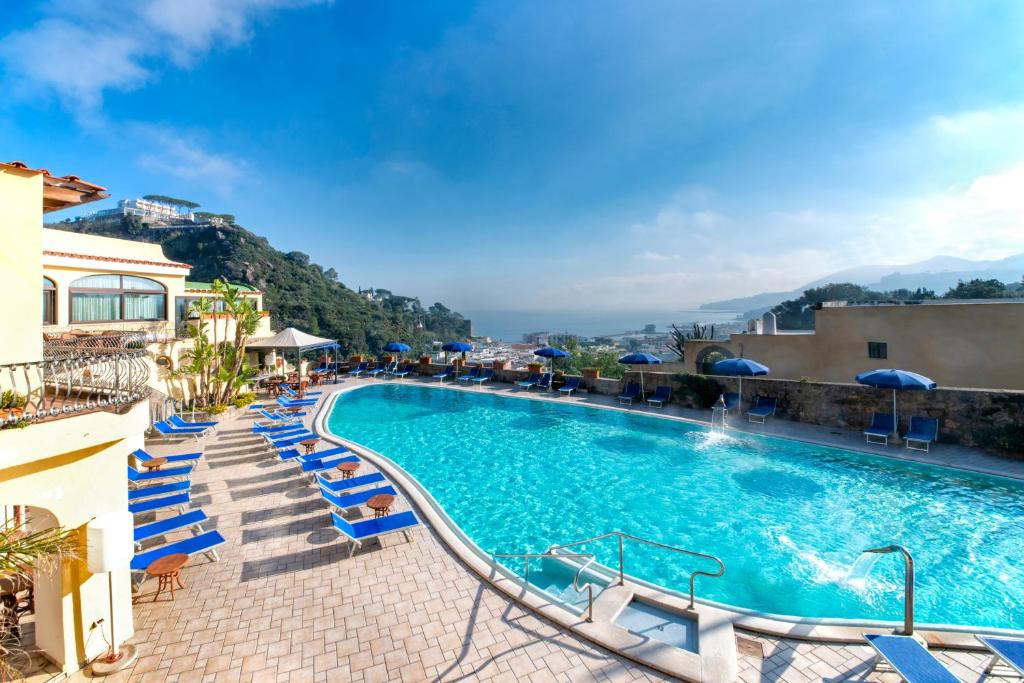 a beach with a pool, chairs, and a pool table at Hotel San Lorenzo Thermal Spa in Ischia