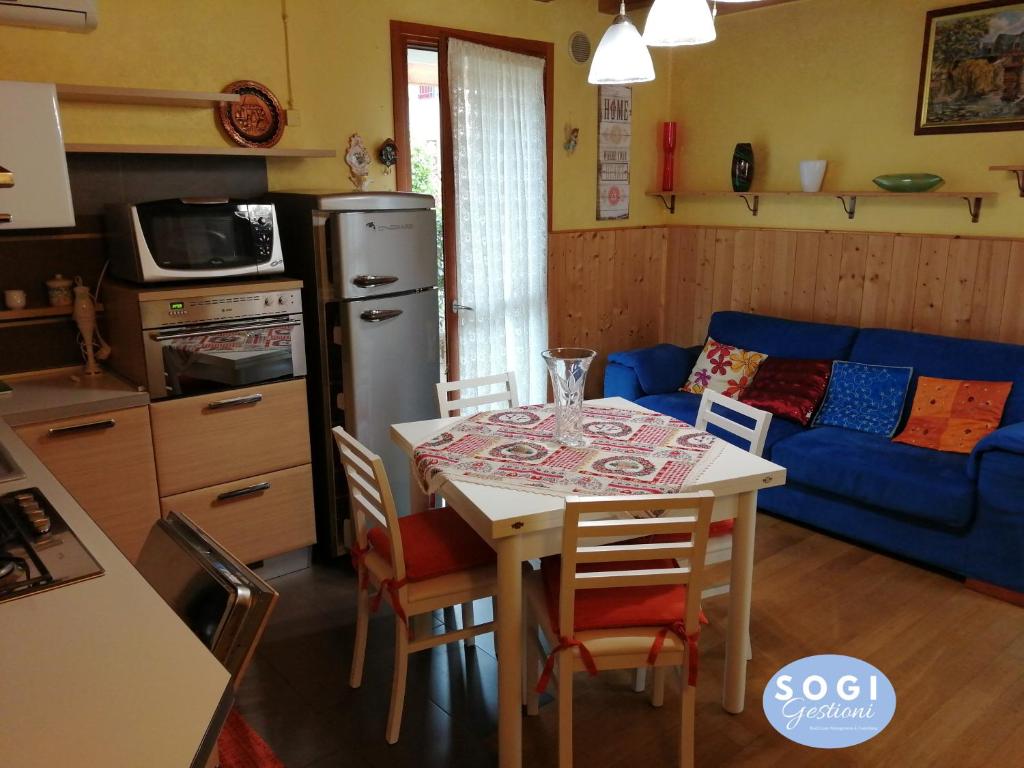 kuchnia i salon ze stołem i niebieską kanapą w obiekcie Casa di Sabry w mieście Cappella Maggiore