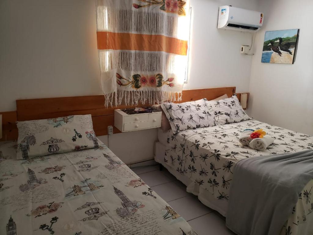 a bedroom with two beds and a window at Casa do Iram e da Ângela- FERNANDO DE NORONHA in Fernando de Noronha